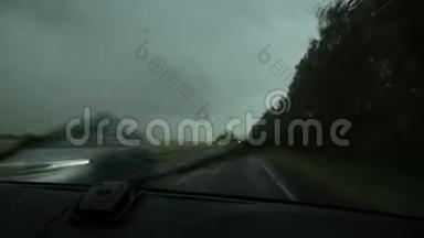 在恶劣的<strong>雨天驾驶</strong>，在汽车行驶过程中通过挡风玻璃观看乡村道路。 窗外的雨滴